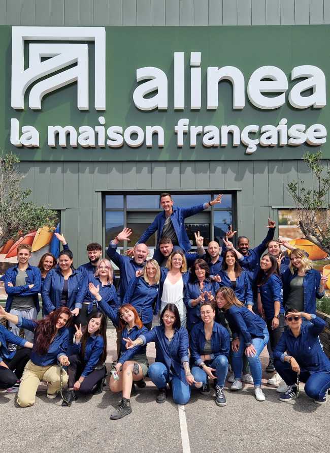 Equipe complète d'un magasin posant devant la devanture